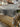 Wholesale liquidation pallet - branded furniture pieces stacked and stretch-wrapped in Dallas TX warehouse, bulk resale furniture load